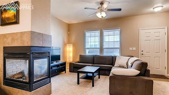 Cozy living room with gas fireplace and recently added luxury wood plank flooring and blinds.