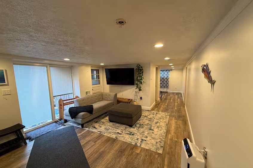 Bright and spacious living area with recessed lighting and modern flooring _ perfect for relaxing or entertaining.