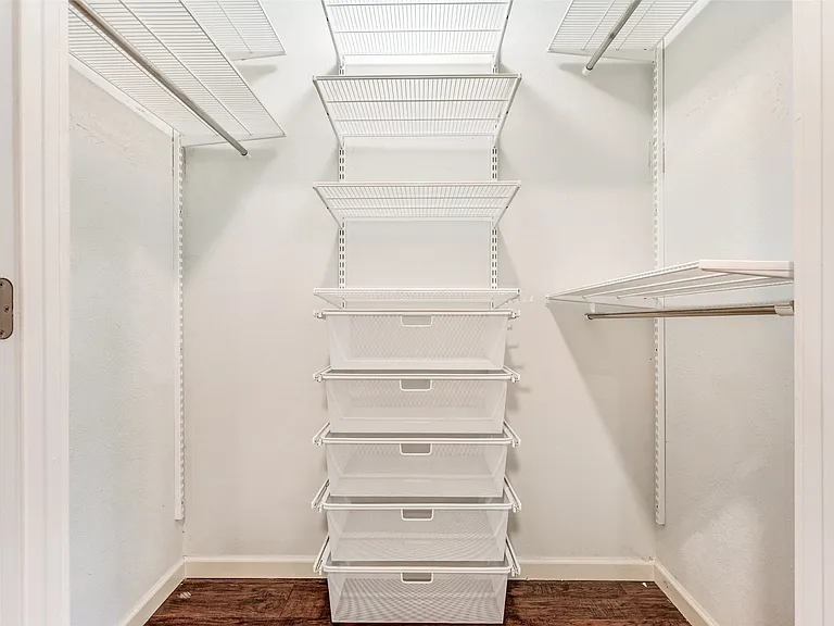 Customizable wire shelving system with hanging rods, integrated pull-out wire baskets, and dark wood-finish flooring