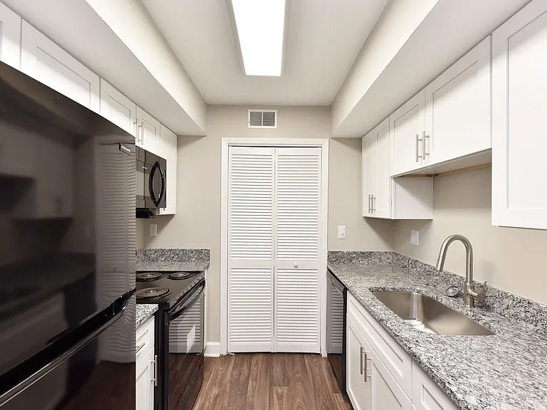 Kitchen with granite counters, black appliances, and modern cabinetry