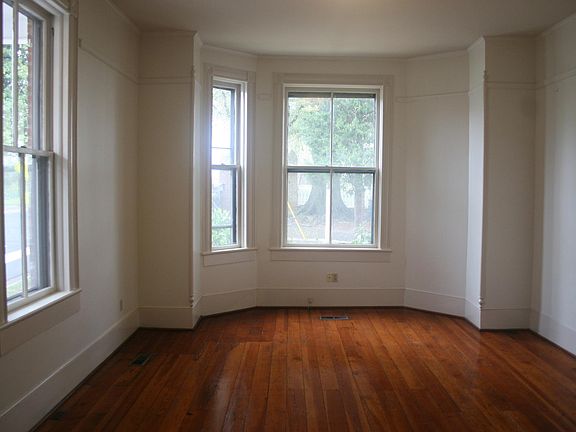 Front living room has large bay and windows, non-functional fire place