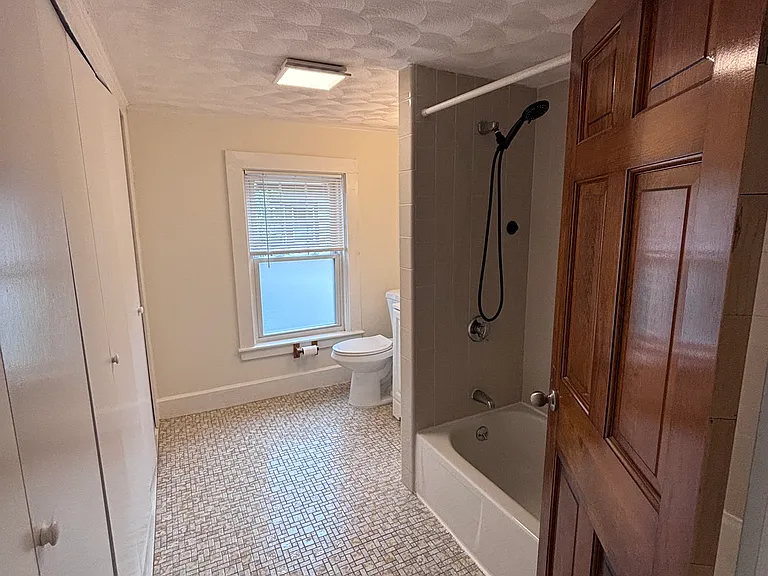 Bathroom with tub and large closet space