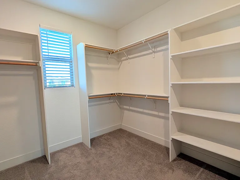 Maximize your storage with this custom-designed walk-in closet. Featuring abundant shelving and natural light, it offers ample space to keep your personal items perfectly tidy, accessible, and well-organized.