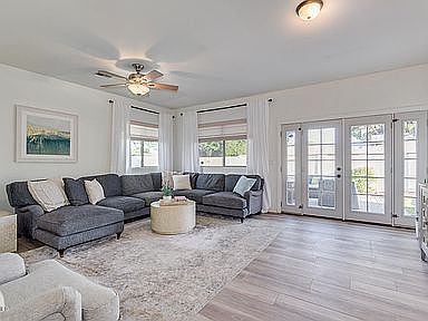 Vaulted living room with abundant natural light and French doors to backyard