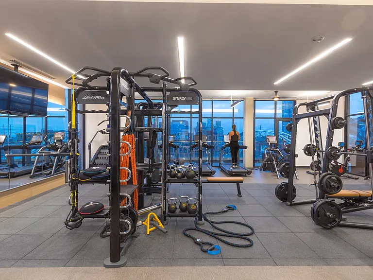 Club-quality fitness center featuring TRX and cardio equipment.