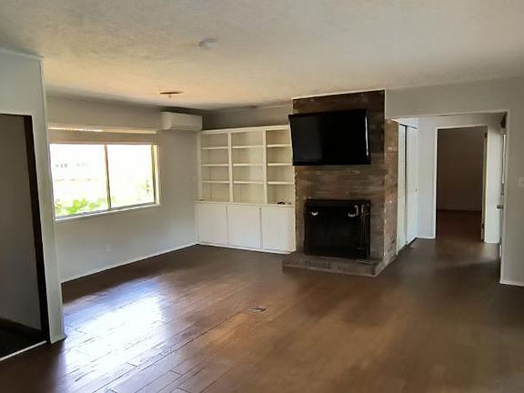 Living room with working fireplace and kitchen.