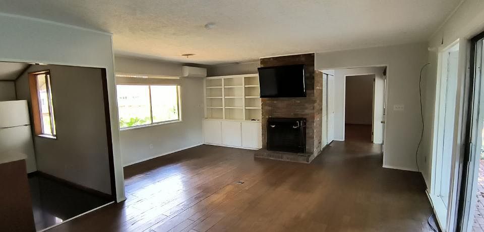 Living room with working fireplace and kitchen.