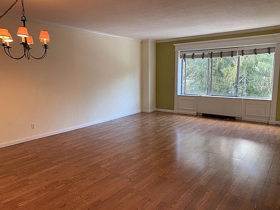 Spacious living room (21' x16') with windows overlooking beautiful mature trees and gardens