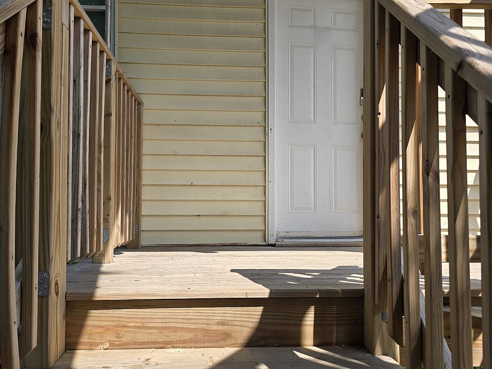 Convenient back porch landing offering easy access to the yard and parking area.
