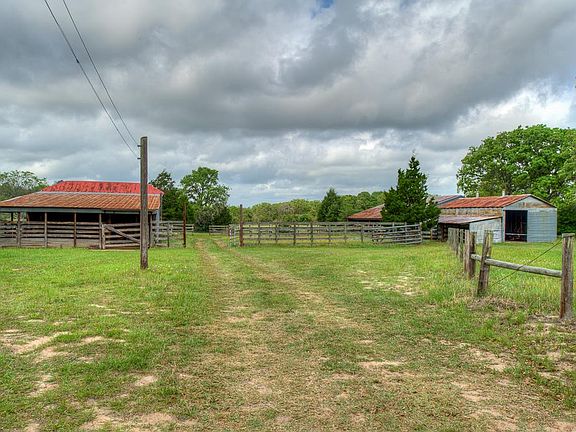 View of 3 barns complete with corrals, cattle handling facilities, 3 pens for horses, 3 water troughs, & tack room