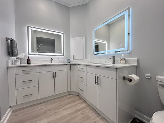 Master Bath with quartzite counter tops and backlit adjustable mirrors.