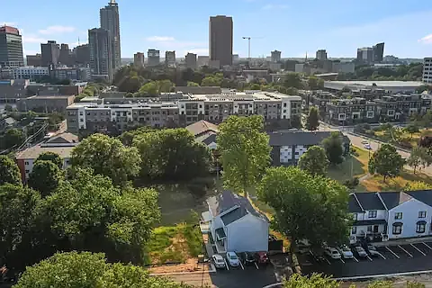 Aerial view of the townhome overlooking park and cityscape beyond.