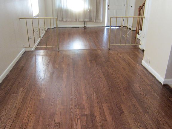 Dining room looking into the sunken Living room & front door. On the right off the dining room is the kitchen then the steps going into the lower level. Off the living room near front door is coat closet then the stairs going to the upper level.