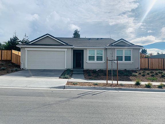 The home showcases modern and elegant curb appeal, with a spacious two-car garage and generous driveway space for added convenience.