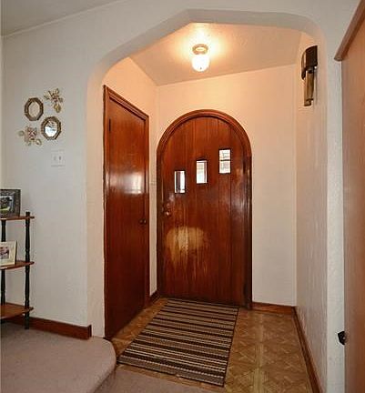Unique curved top door opens to the entry with a convenient coat closet.