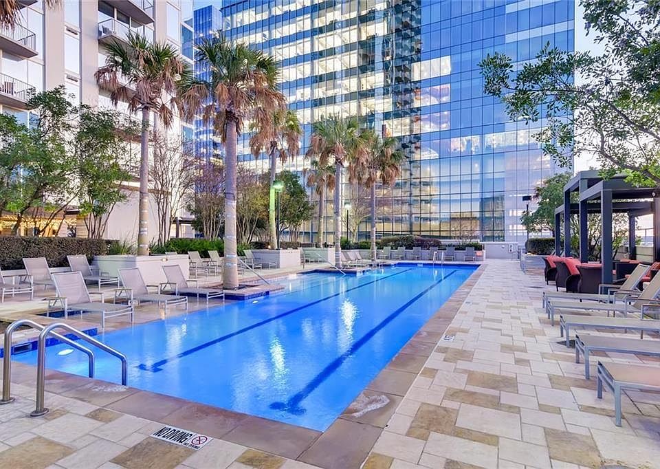 the swimming pool has cabanas and seating around it