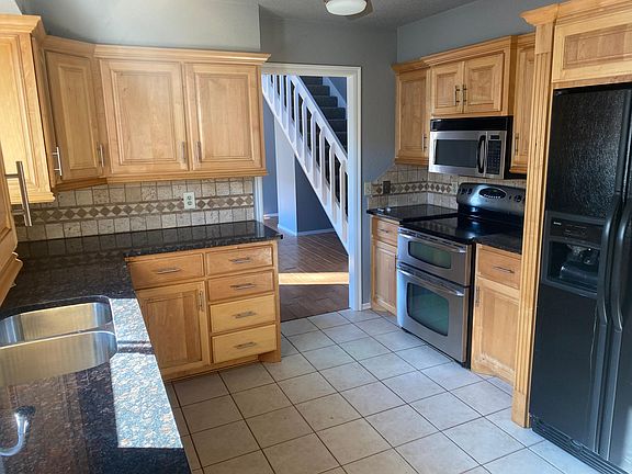 Kitchen with fridge, microwave, stove top and double oven.