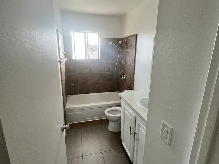 2nd floor bath with tub/shower combo, stone look tub surround, contemporary tile floor, quartz counter top, updated lighting and plumbing fixtures!