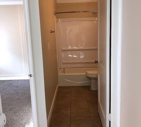 Bathroom ahead and door to bedroom on left.