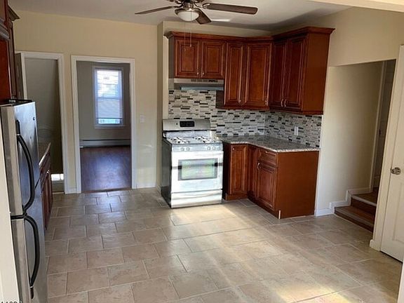 Kitchen w. Wooden cabinets/ Stove/Refrigerator/ Ceiling Fan