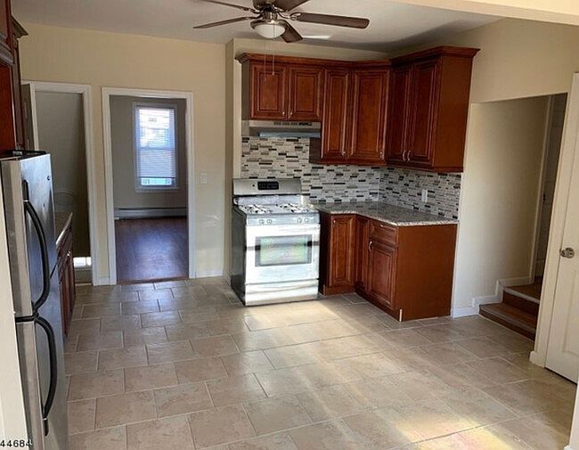 Kitchen w. Wooden cabinets/ Stove/Refrigerator/ Ceiling Fan