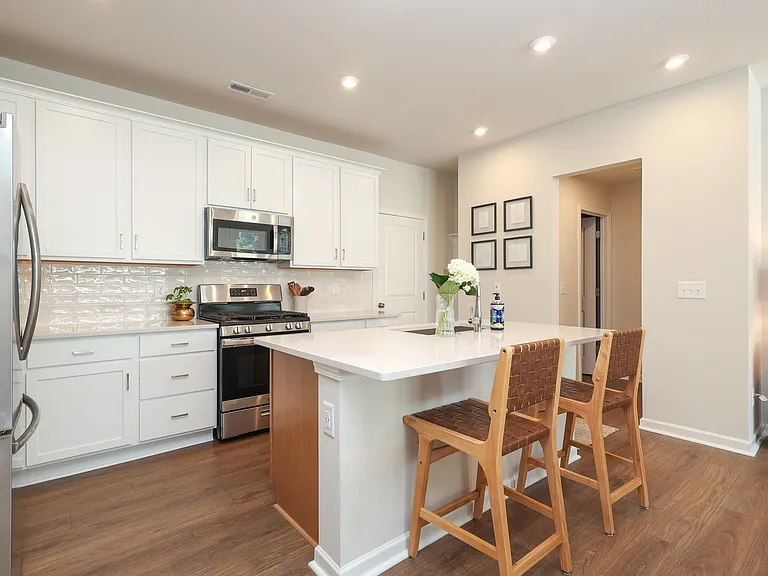 Open concept kitchen with quartz countertops and stainless steel appliances