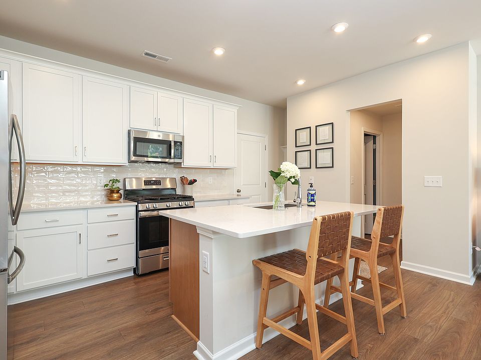 Open concept kitchen with quartz countertops and stainless steel appliances