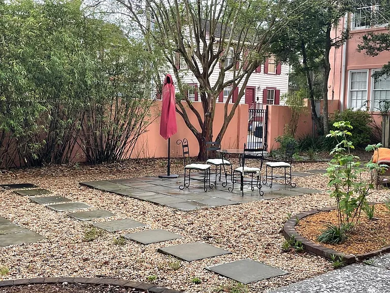 Common courtyard with outdoor dining table, bike rack, parking on other side of the wall