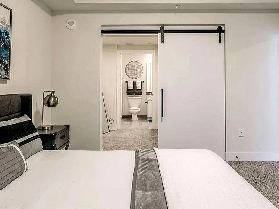 Griffis Pompano Beach Apartment Bedroom with attached bathroom and plush carpet