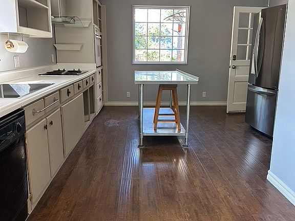 Farm sink, island prep table, refrigerator, dishwasher, venthood, electric stove, and oven