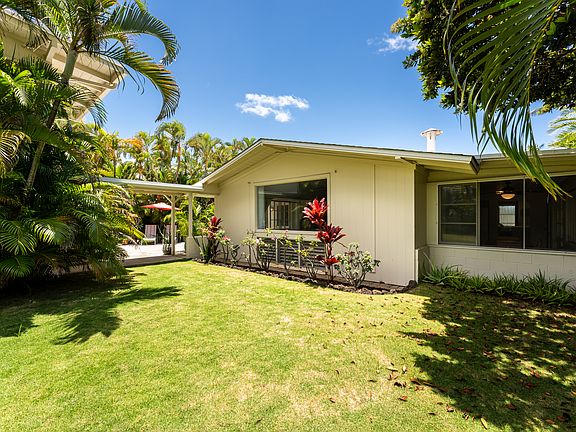 Private landscaped yard area between the main home and detached cottage with mature tropical landscaping and covered walkways.