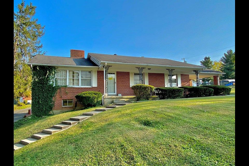 Front view with stairs from lower driveway that circles around to carport.