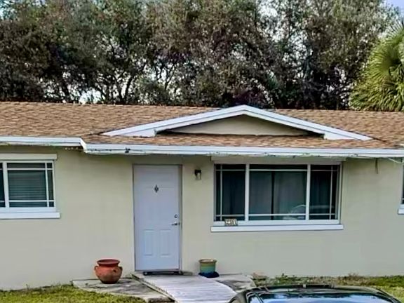 Front of home, circular driveway, large front and back yard.