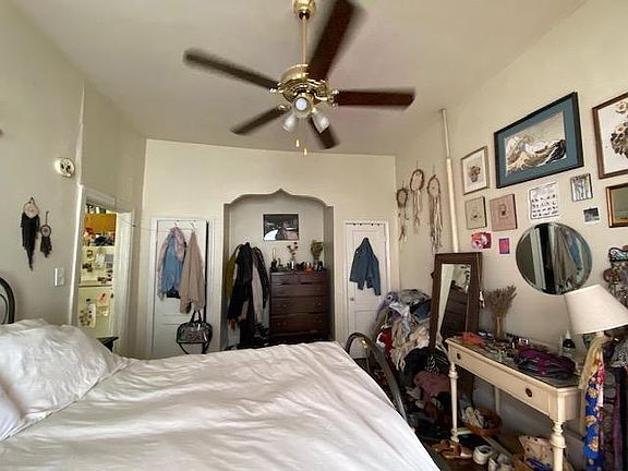 Bedroom with interesting built in storage area and ceiling fan