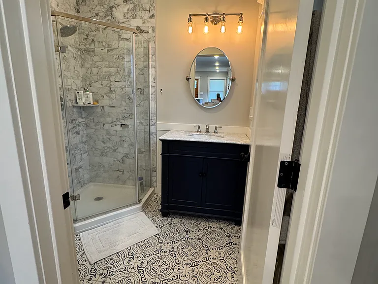 1st floor full bathroom with shower, marble tiles.