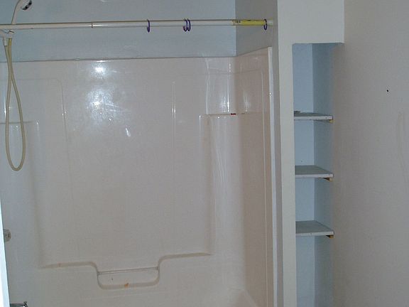 Full bath is opposite a large laundry room