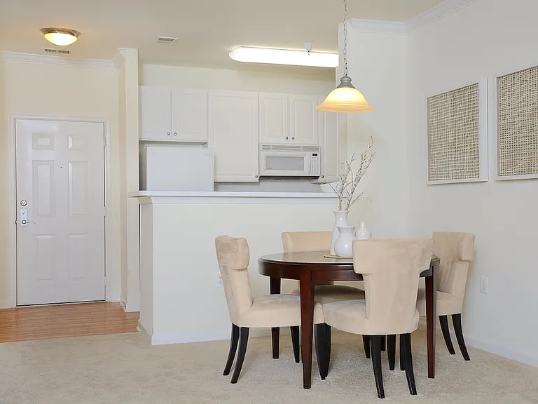 Classic I dining area with carpeted flooring and kitchen with white cabinetry, white appliances, and hard surface flooring