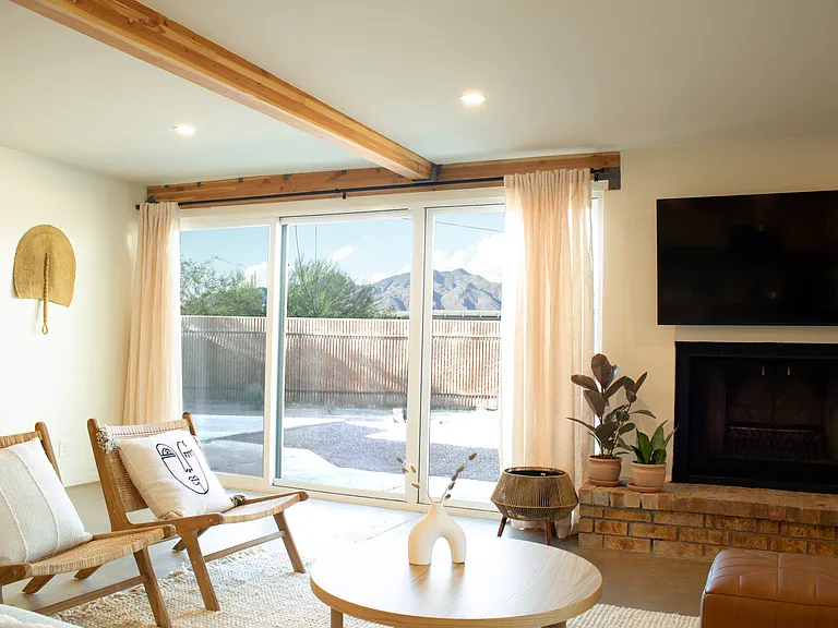 Light-filled living room with fireplace and seamless indoor-outdoor access.