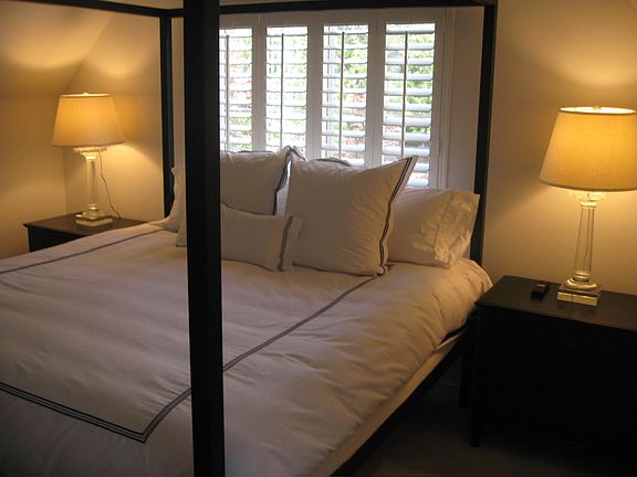 The apartment bedroom. A large dresser is out of view to the left and the work/desk area is out of view to the right. A walk-in closet is directly behind the camera.