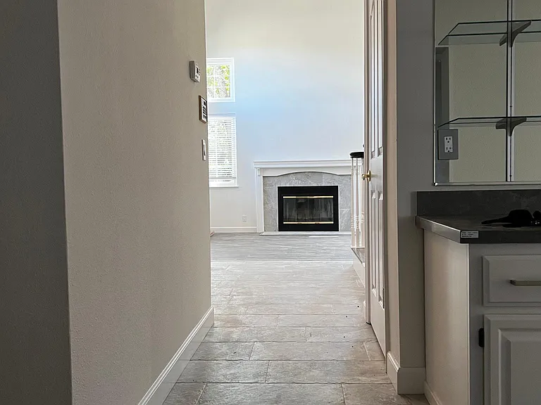 View the living room, fireplace and foyer, as viewed for hallway