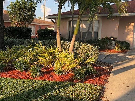 Mature mahogany trees and triple palms provide shade and privacy.