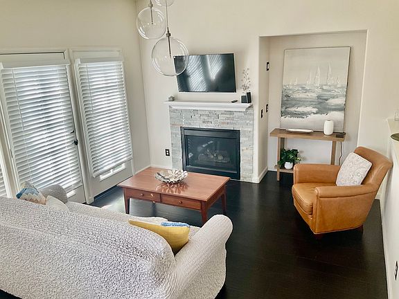 Living Room
Bright, cozy living space with a designer fireplace and modern touches. Natural light fills the room through double patio doors, creating a warm, inviting ambiance.