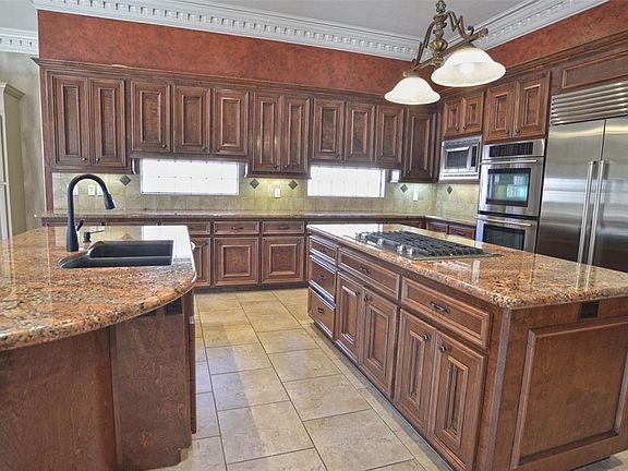Kitchen features 2 islands with 5-burner gas Jennair cooktop, Jennair double ovens and Sub-Zero refrigerator.