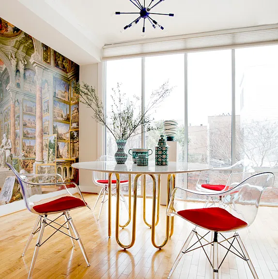 One wall is a luxe mural based on a 1757 painting in the MET. Another wall is floor to ceiling glass. The table is Adler.