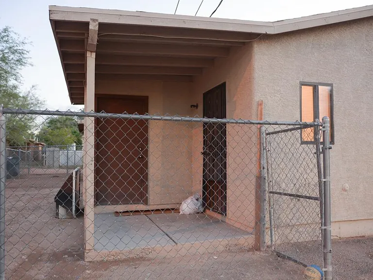 Fenced backyard with patio and storage/laundry room
