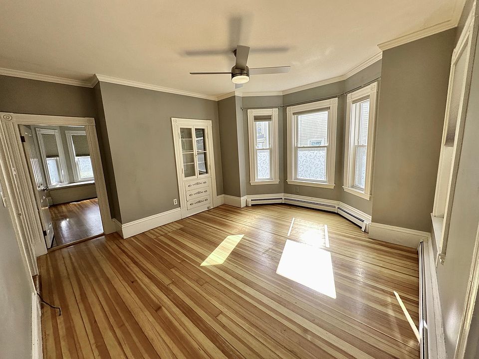 Living Room with real hardwood floors throughout, tons of natural light, and an original built i cabinet.