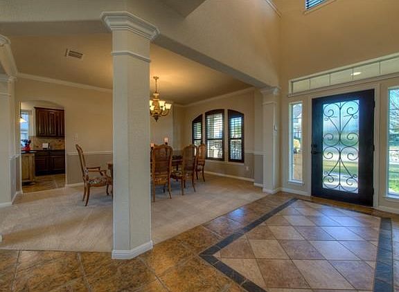 Grand entry with custom tile.  Formal dining has gorgeous upgraded chandelier with a finish that matches the kitchen island.  Plantation shutters are real wood.