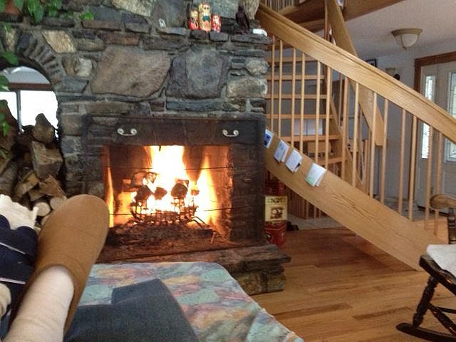 In front of living room fireplace facing oak spiral staircas