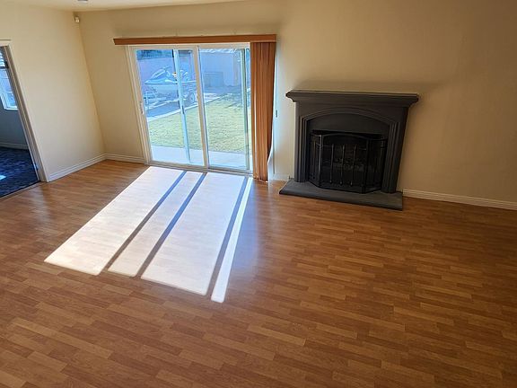 Family room with natural fireplace and laminate flooring.