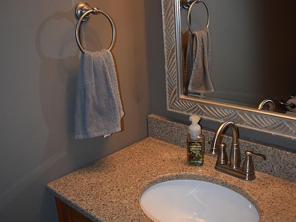 Recently remodeled half-bathroom off kitchen with new vanity and quartz countertops